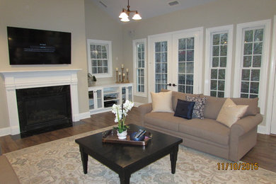 Huge elegant open concept porcelain tile family room photo in Raleigh with a standard fireplace and a wall-mounted tv