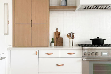 Modern inredning av ett mellanstort grå grått kök, med en undermonterad diskho, släta luckor, vita skåp, bänkskiva i koppar, vitt stänkskydd, stänkskydd i keramik, rostfria vitvaror, ljust trägolv och en köksö