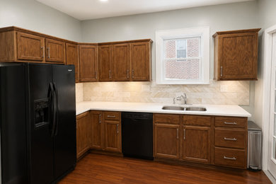 Example of a classic kitchen design in Cincinnati with an undermount sink, dark wood cabinets, quartzite countertops and stone tile backsplash