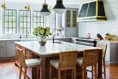 Large transitional u-shaped medium tone wood floor and brown floor eat-in kitchen photo in New York with an undermount sink, recessed-panel cabinets, gray cabinets, marble countertops, white backsplash, ceramic backsplash, black appliances, an island and white countertops