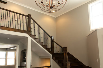 Large transitional wooden curved staircase photo in Indianapolis with wooden risers