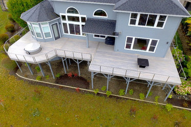 Photo of a large modern backyard deck in Seattle with no cover and a fire feature.