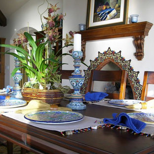 Foto di una sala da pranzo mediterranea chiusa e di medie dimensioni con pareti bianche, camino classico e cornice del camino in pietra
