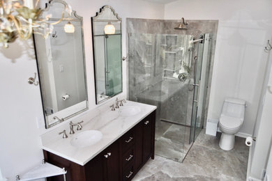 Bathroom - mid-sized transitional master porcelain tile, multicolored floor and double-sink bathroom idea in New York with shaker cabinets, dark wood cabinets, a one-piece toilet, white walls, an undermount sink, quartz countertops, white countertops, a niche and a freestanding vanity