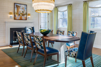 Example of a mid-sized trendy medium tone wood floor and brown floor enclosed dining room design in New York with beige walls and a standard fireplace