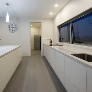 Large contemporary kitchen pantry pictures - Large trendy galley kitchen pantry photo in Hamilton with an integrated sink, granite countertops, white backsplash, stainless steel appliances and an island