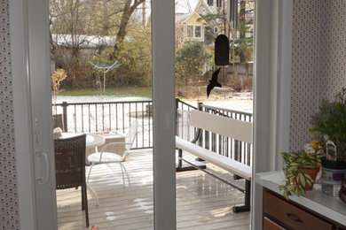 Ejemplo de terraza planta baja de tamaño medio sin cubierta en patio trasero con zócalos y barandilla de metal