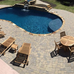 Mittelgroßer Uriger Schwimmteich hinter dem Haus in Nierenform mit Wasserspiel und Betonplatten in Atlanta