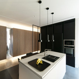 Diseño de cocina blanco y madera, moderna, grande, abierta, con fregadero encastrado, armarios con paneles empotrados, con blanco y negro, encimera de mármol, electrodomésticos con paneles, suelo de baldosas de porcelana, una isla, suelo gris y encimeras blancas