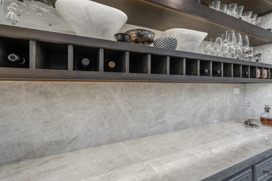 Inspiration for a mid-sized timeless home bar remodel in Houston with floating shelves, gray cabinets, granite countertops, multicolored backsplash, mosaic tile backsplash and multicolored countertops