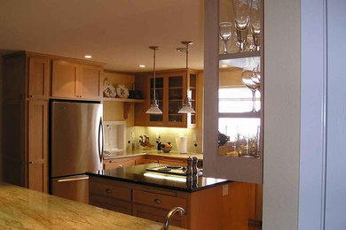 Photo of a traditional l-shaped eat-in kitchen in San Diego with medium wood cabinets, white splashback, stainless steel appliances and with island.