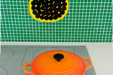 Inspiration for a contemporary kitchen remodel in Other with green backsplash, glass tile backsplash and white countertops