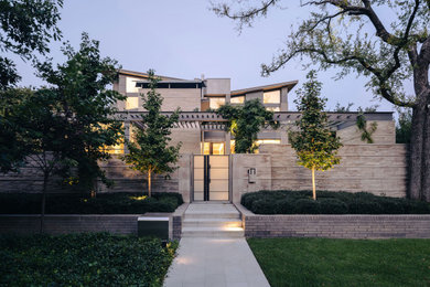 Large trendy gray three-story brick house exterior photo in Dallas with a butterfly roof, a metal roof and a gray roof