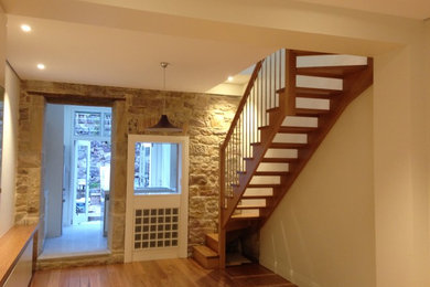 This is an example of a small modern wood straight staircase in Sydney with wood risers and wood railing.
