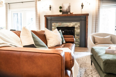 Mittelgroßes Klassisches Wohnzimmer mit weißer Wandfarbe, braunem Holzboden, Kamin, gefliester Kaminumrandung, TV-Wand und braunem Boden in Denver
