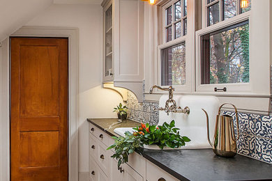 Example of a small classic medium tone wood floor mudroom design in Detroit with white walls