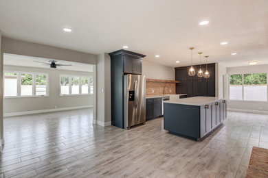 Mid-sized transitional u-shaped porcelain tile and gray floor eat-in kitchen photo in Phoenix with a farmhouse sink, shaker cabinets, blue cabinets, quartz countertops, red backsplash, brick backsplash, stainless steel appliances, an island and white countertops