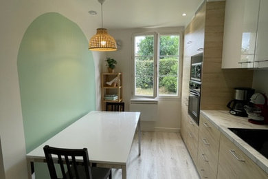 Photo of a medium sized contemporary l-shaped open plan kitchen in Paris with a submerged sink, beaded cabinets, light wood cabinets, marble worktops, white splashback, black appliances, light hardwood flooring, no island, beige floors and white worktops.