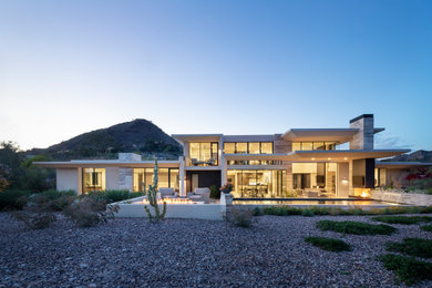 Huge modern white two-story stone exterior home idea in Phoenix