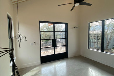 Example of a cottage master concrete floor, gray floor and exposed beam bedroom design in Austin with white walls