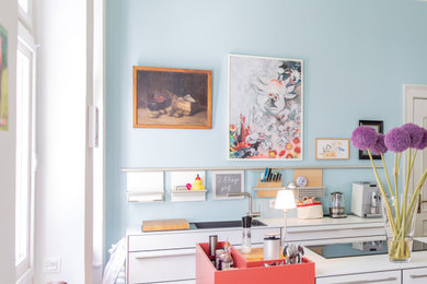 Moderne Wohnküche mit Küchenrückwand in Blau, braunem Holzboden und Kücheninsel in Düsseldorf
