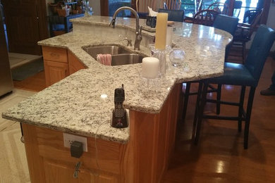 Inspiration for a craftsman kitchen remodel in Indianapolis with an undermount sink, granite countertops, white backsplash, glass tile backsplash, stainless steel appliances and an island