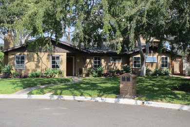 Inspiration for a mid-sized timeless beige one-story stucco gable roof remodel in Orange County