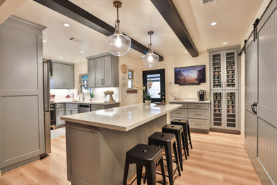 Transitional u-shaped kitchen photo in Houston with shaker cabinets, gray cabinets, solid surface countertops, mosaic tile backsplash, an island and white countertops