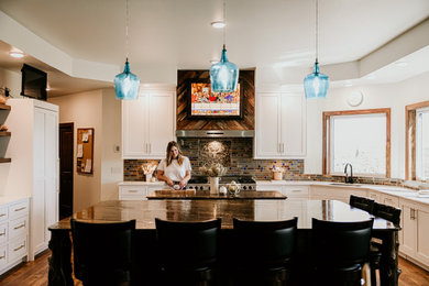 Inspiration for a large cottage u-shaped light wood floor and brown floor eat-in kitchen remodel in Other with an undermount sink, shaker cabinets, white cabinets, quartzite countertops, brown backsplash, stone tile backsplash, paneled appliances, two islands and brown countertops