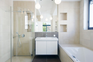 Großes Modernes Badezimmer En Suite mit integriertem Waschbecken, flächenbündigen Schrankfronten, weißen Schränken, Einbaubadewanne, Eckdusche, beigen Fliesen und beiger Wandfarbe in Leipzig