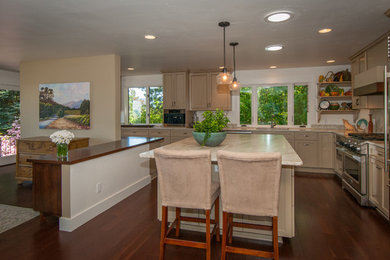 Eat-in kitchen - craftsman l-shaped eat-in kitchen idea in Seattle with white cabinets, granite countertops, an island, recessed-panel cabinets and stainless steel appliances