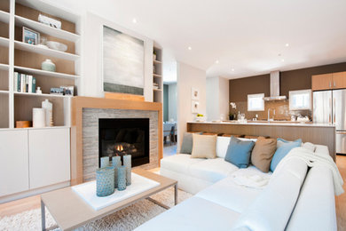 Living room - large contemporary open concept light wood floor living room idea in Vancouver with white walls, a standard fireplace and a stone fireplace
