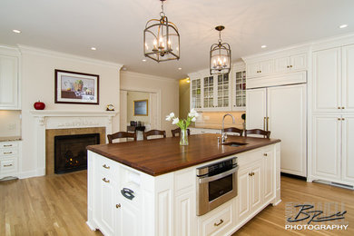 Inspiration for a timeless u-shaped enclosed kitchen remodel in Other with beaded inset cabinets, white cabinets, wood countertops and an island