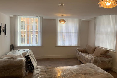 Photo of a medium sized contemporary open plan living room in Other with a home bar, white walls, laminate floors, no fireplace and a concealed tv.