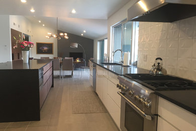 Kitchen - contemporary ceramic tile and gray floor kitchen idea in Phoenix with an undermount sink, flat-panel cabinets, white cabinets, wood countertops, white backsplash, ceramic backsplash, stainless steel appliances and an island