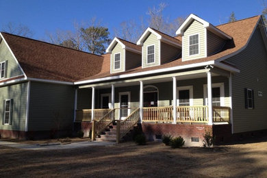 Large elegant green two-story concrete fiberboard house exterior photo in Other with a clipped gable roof and a shingle roof