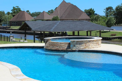 Large elegant backyard concrete and custom-shaped natural hot tub photo in Houston
