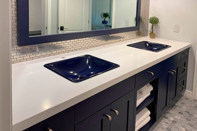 Example of a mid-sized mirror tile powder room design in Denver with flat-panel cabinets, blue cabinets, a drop-in sink, quartz countertops, white countertops and a built-in vanity