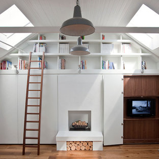 Idéer för mellanstora funkis vardagsrum, med vita väggar, mellanmörkt trägolv, en standard öppen spis och en dold TV