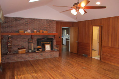 Mid-sized elegant enclosed family room photo in Cleveland with brown walls, a standard fireplace and a brick fireplace