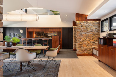 Réalisation d'une grande salle à manger ouverte sur la cuisine vintage avec un mur blanc et un plafond voûté.