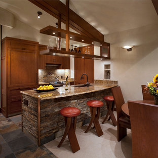 Неиссякаемый источник вдохновения для домашнего уюта: маленькая параллельная кухня в современном стиле с столешницей из гранита, обеденным столом, врезной раковиной, фасадами с утопленной филенкой, фасадами цвета дерева среднего тона, бежевым фартуком, фартуком из каменной плитки, техникой под мебельный фасад, полом из сланца и островом