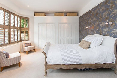 This is an example of a mid-sized contemporary master bedroom in London with grey walls and carpet.