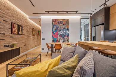 Modelo de sala de estar tipo loft industrial de tamaño medio con suelo de madera en tonos medios, televisor colgado en la pared y ladrillo