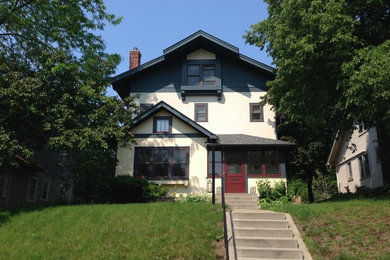 This is an example of a mid-sized arts and crafts two-storey exterior in Minneapolis with mixed siding and a clipped gable roof.