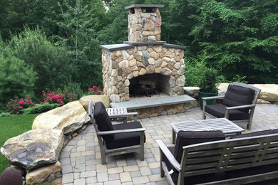 Photo of a mid-sized country backyard patio in Bridgeport with a fire feature, concrete pavers and no cover.