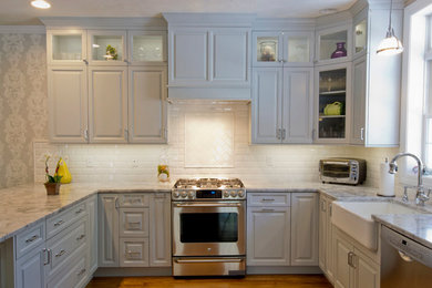 Inspiration for a transitional u-shaped medium tone wood floor eat-in kitchen remodel in Manchester with a farmhouse sink, raised-panel cabinets, gray cabinets, quartzite countertops, white backsplash, subway tile backsplash, stainless steel appliances and a peninsula