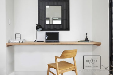 Modelo de despacho minimalista grande con paredes blancas y escritorio empotrado