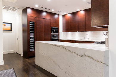 Eat-in kitchen - mid-sized modern u-shaped dark wood floor and brown floor eat-in kitchen idea in Dallas with an undermount sink, flat-panel cabinets, medium tone wood cabinets, quartz countertops, white backsplash, stone slab backsplash, stainless steel appliances, a peninsula and white countertops