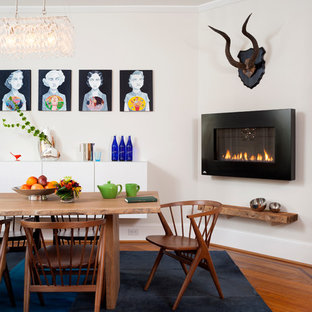 ワシントンD.C.の広いミッドセンチュリースタイルのLDKの画像 (白い壁、無垢フローリング、金属の暖炉まわり、横長型暖炉、茶色い床)